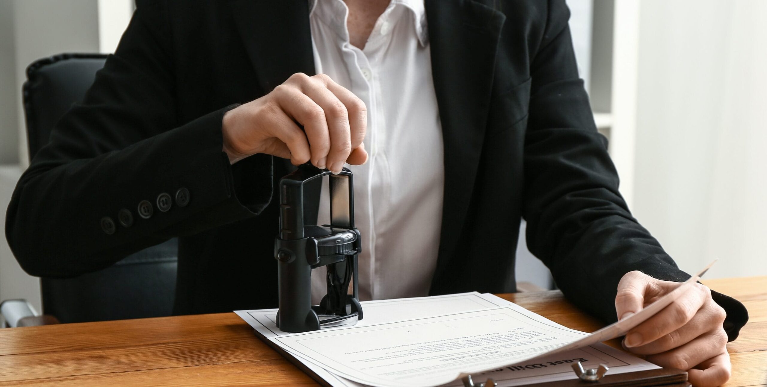 Eine Frau stempelt Dokumente ab für ein GoBD-konformes Kassensystem.