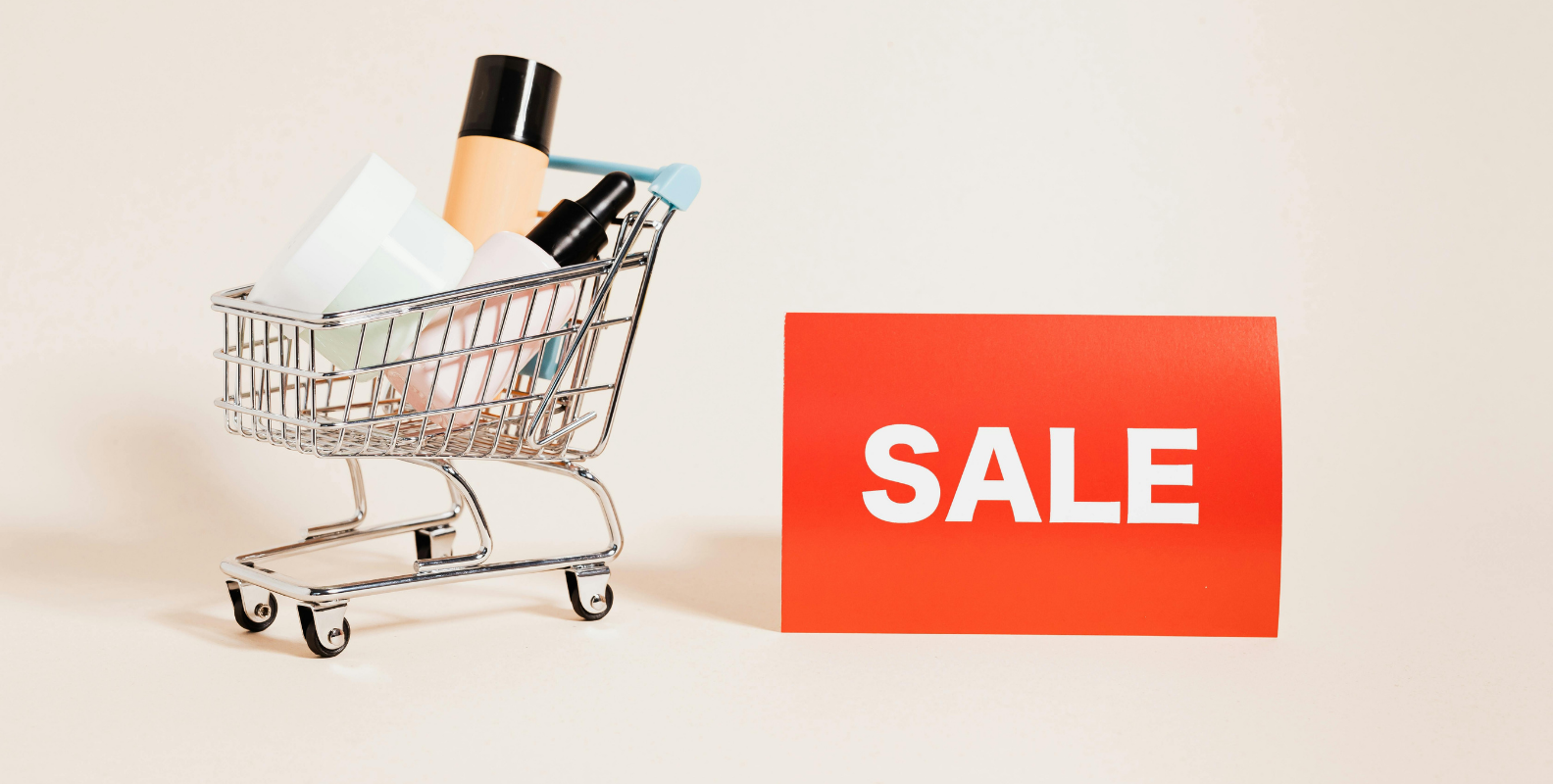 Kosmetikprodukte in einem kleinen Einkaufswagen mit einem Sale-Schild.