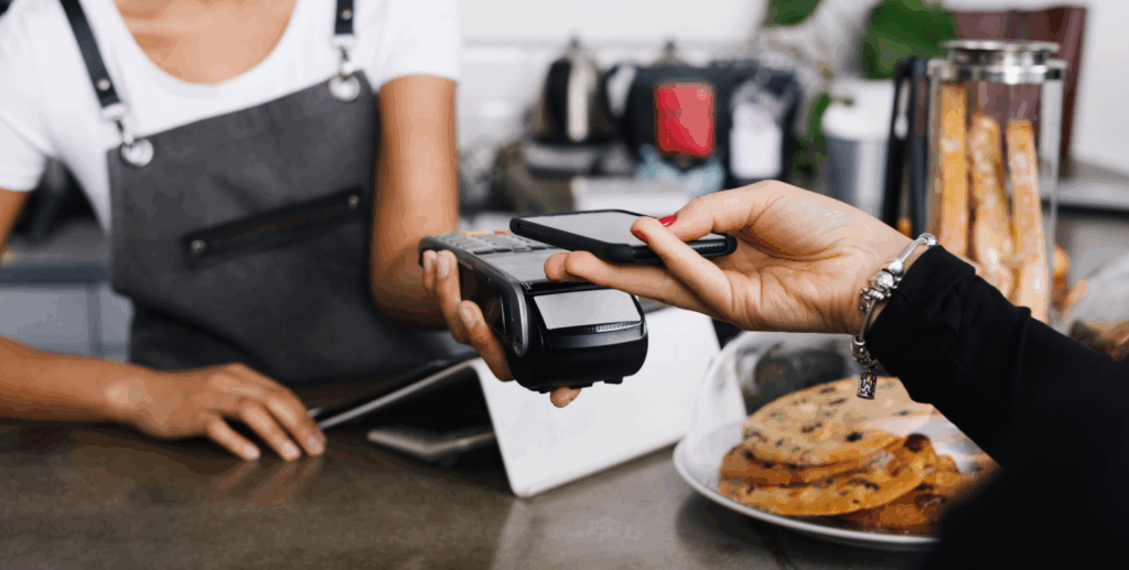 Eine Kundin zahlt an einem POS-Gerät mit dem Smartphone.